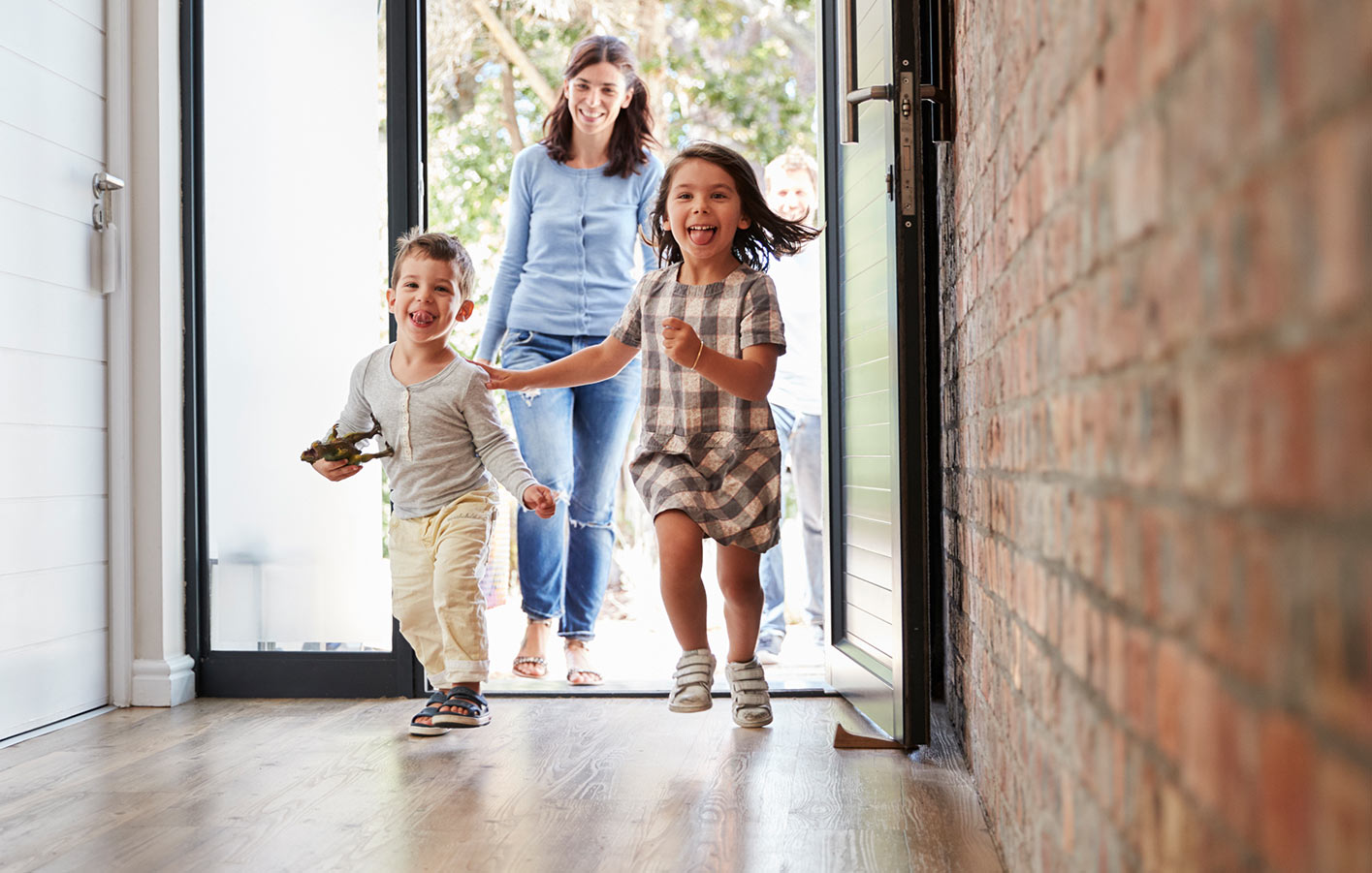 Kinder rennen ins Haus durch die geöffnete Haustür